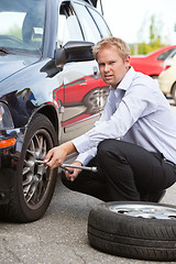 Image showing Business Man Replacing Tire