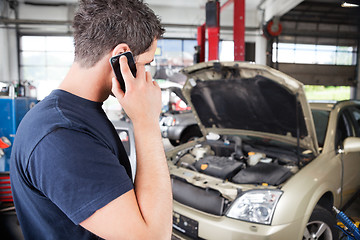 Image showing Mechanic talking on cell phone