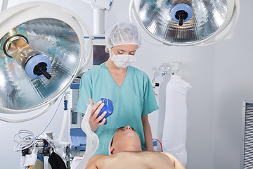 Image showing Doctor applying oxygen mask