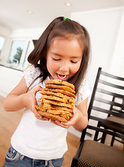 Image showing Young Girl Eating Stack of Cookies