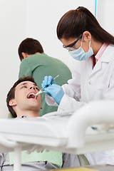 Image showing Dentist working on patient's teeth