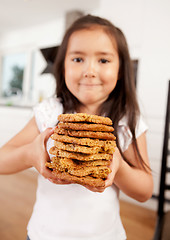 Image showing Young Girl Holding Stack of Cookies