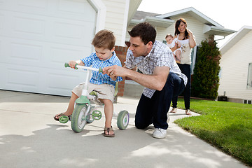 Image showing Father Teaching Son To Ride Tricycle