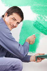 Image showing Handsome man painting house