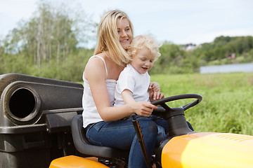 Image showing Mother and Child mowing grass