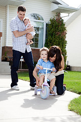 Image showing Mother Teaching Son To Ride Tricycle