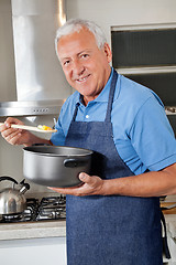 Image showing Man Holding Spoon to Taste Food