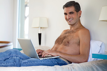 Image showing Shirtless Man Working on Laptop