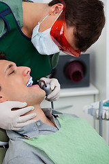 Image showing Dentist working on tooth at dental clinic