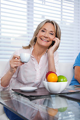 Image showing Woman Using Cell Phone at Breakfast Table