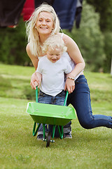 Image showing Mother and Son Pushing a Wheelbarrow