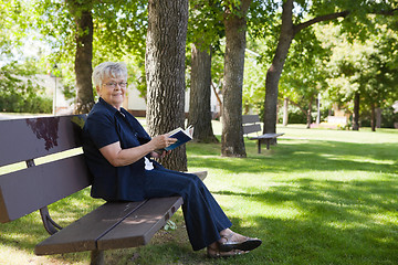 Image showing Woman reading book in a park