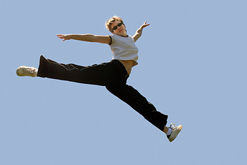 Image showing Young woman jumping high