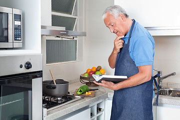 Image showing Senior Man Holding Recipe Book