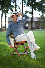 Image showing Casual Man Sitting in Park Holding Tablet PC