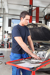 Image showing Mechanic using laptop in garage