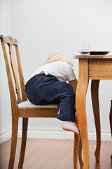 Image showing Child trying to get down from chair