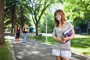 Image showing College girl standing with a book