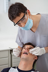 Image showing Dentist examining patient's teeth