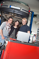 Image showing Couple standing with mechanic using laptop