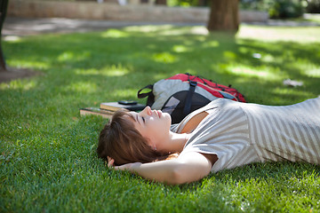 Image showing Girl lying on grass at campus lawn