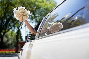 Image showing Bride waving hand holding bouquet