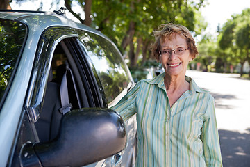 Image showing Senior woman standing near car