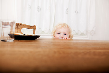 Image showing Child Peeking Over Table