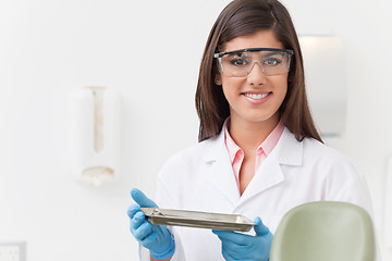 Image showing Dentist holding tray of dental instruments