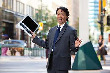 Image showing Businessman holding laptop and laughing