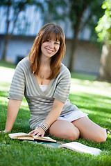 Image showing Female sitting with book on grass