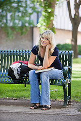 Image showing Young female student sitting on bench