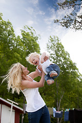 Image showing Mother Throwing Son in Air