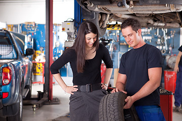 Image showing Mechanic Showing Tire to Woman Customer