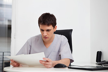 Image showing Doctor reading reports