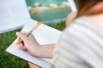 Image showing Girl writing in a notebook