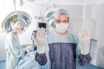 Image showing Male surgeon asking for gloves