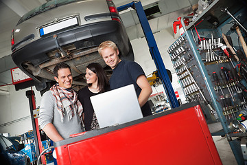 Image showing Couple in auto repair shop standing with mechanic