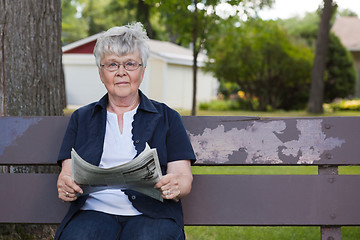 Image showing Senior Woman Reading Newspaper in Park