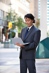 Image showing Smiling businessman using laptop