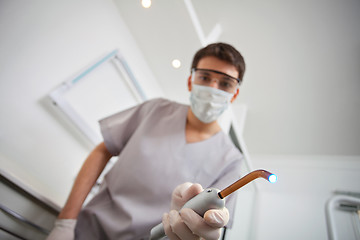 Image showing Dentist holding ultraviolet light