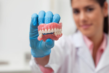 Image showing Female dentist holding dental mold