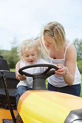 Image showing Young Boy with Mother on Garden Tractor