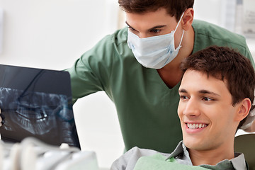Image showing Patient looking at his tooth x-ray