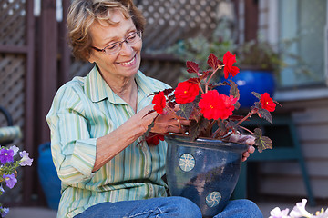 Image showing Woman looking at flower pot