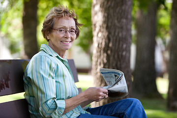 Image showing Woman reading newspaper in park