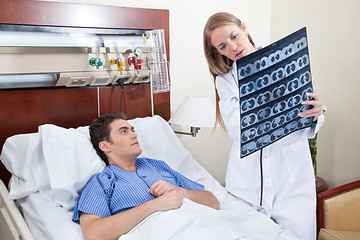 Image showing Doctor and patient examining X-ray report
