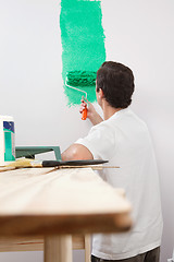 Image showing Man paining house with roller