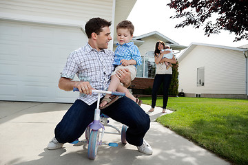 Image showing Playful Father Sitting on Tricycle With Son