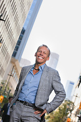 Image showing Businessman standing with buildings in background